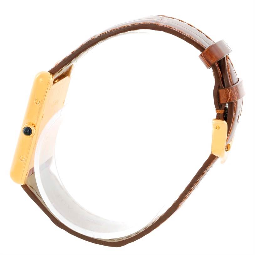 The image shows a side view of the Cartier Tank Louis W1529756 Men's Yellow Gold Silver Dial W1529756 Men's Yellow Gold Silver Dial model, highlighting its gold case, crown, and brown leather strap.