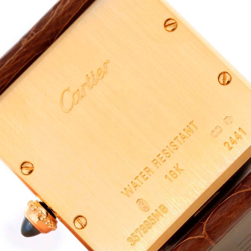 This image shows the back of the Tank Louis watch by Cartier, highlighting its engravings and part of the leather strap.