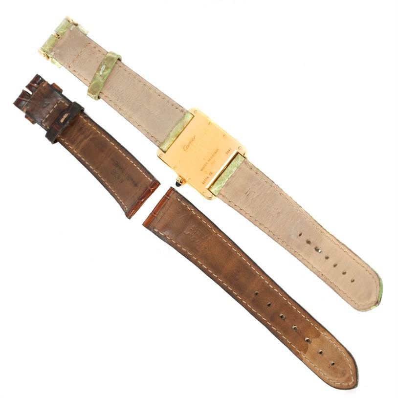 This image shows the back of a Cartier Tank Louis W1529756 Men's Yellow Gold Silver Dial W1529756 Men's Yellow Gold Silver Dial watch and two additional leather straps.