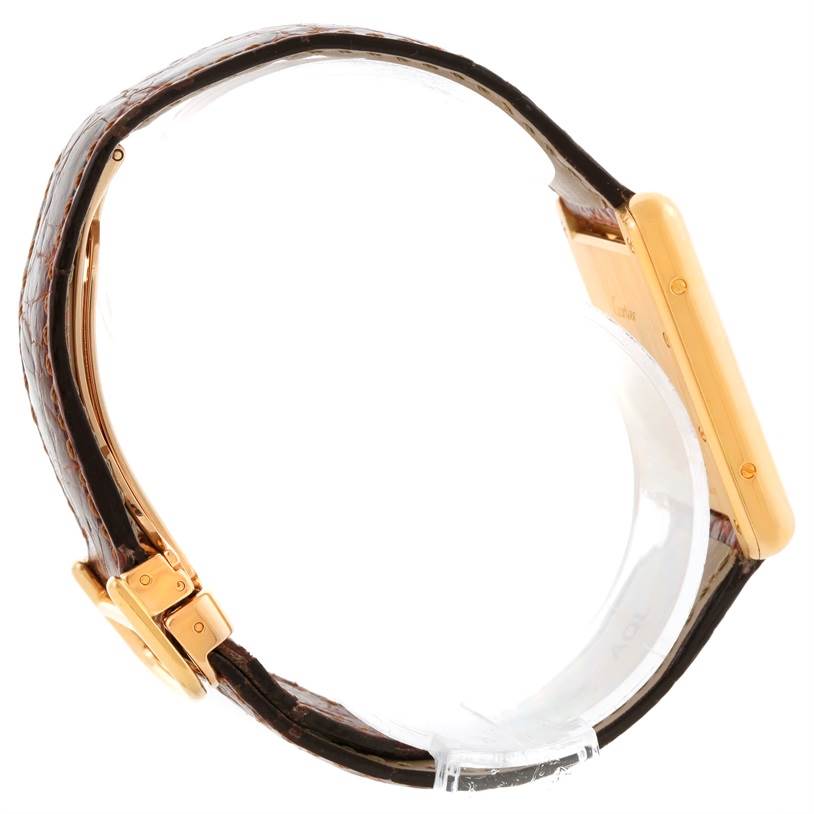 Side view of a Cartier Tank Louis W1529756 Yellow Gold Silver Dial W1529756 Yellow Gold Silver Dial watch showing its gold case and dark leather strap.