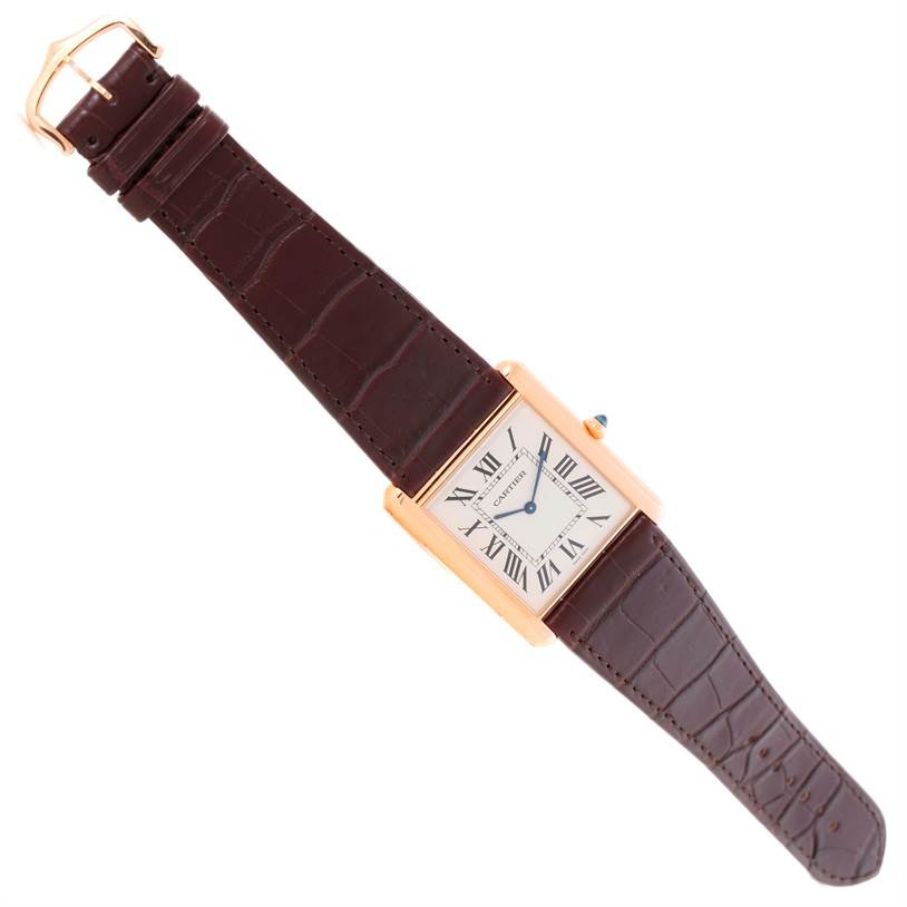 The Cartier Tank Louis W1560017 Men's Rose Gold Silver Dial W1560017 Men's Rose Gold Silver Dial watch is shown from a top-down angle, displaying its rectangular face and the entirety of its leather strap.