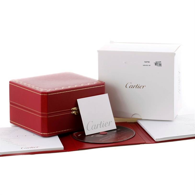 The image shows the packaging accessories for the Cartier Tank Louis W1560017 Men's Rose Gold Silver Dial W1560017 Men's Rose Gold Silver Dial watch, including a red box, booklet, and CD.