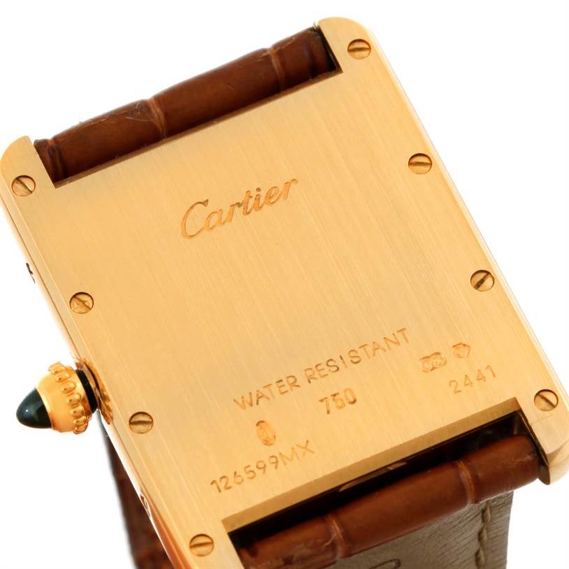 The image shows the back of a Tank Louis model watch by Cartier, highlighting the engravings and leather strap attachment.