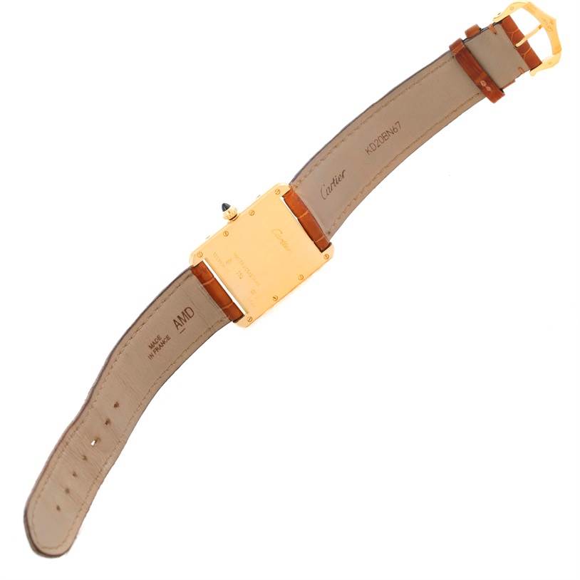 The image shows the back side of the Cartier Tank Louis Men's Yellow Gold Silver Dial Men's Yellow Gold Silver Dial watch, featuring the buckle and leather straps.