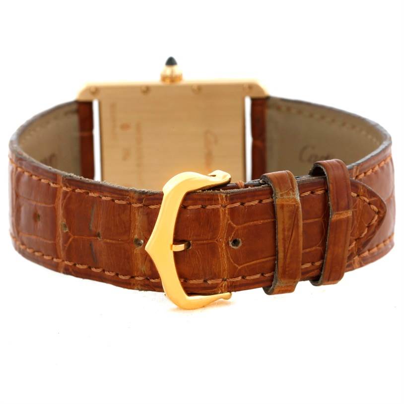 This image shows the back view of a Tank Louis model by Cartier, highlighting the leather strap and gold buckle.