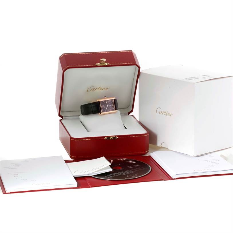 The image shows a Cartier Tank Louis W1560002 Men
s Rose Gold Brown Dial W1560002 Men
s Rose Gold Brown Dial watch in a red box, with accompanying accessories including a disk and documents.