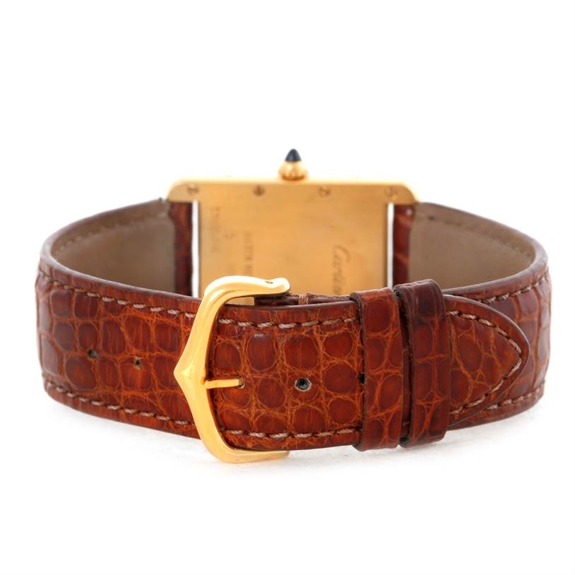 This image shows the back of a Cartier Tank Louis W1529756 Men's Yellow Gold Silver Dial W1529756 Men's Yellow Gold Silver Dial watch with a brown leather strap and gold buckle.