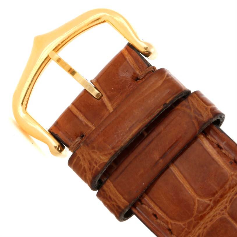This image shows the brown leather strap and gold buckle of a Cartier Tank Louis W1529756 Men's Yellow Gold Silver Dial W1529756 Men's Yellow Gold Silver Dial watch, viewed from above.