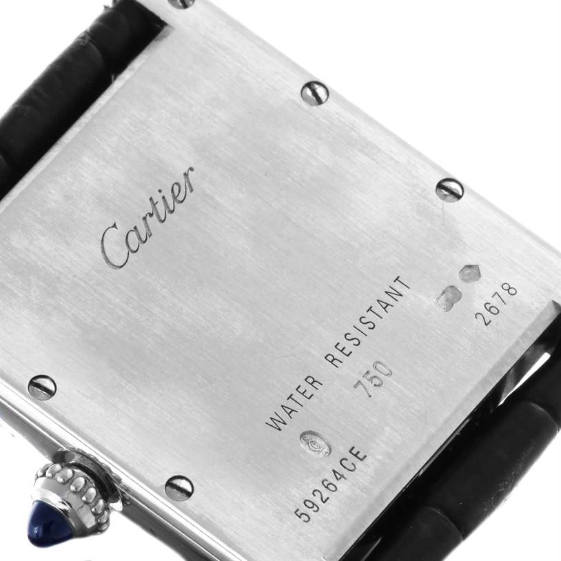The image shows the back case and crown of a Cartier Tank Louis W1540956 Men's White Gold White Dial W1540956 Men's White Gold White Dial watch, displaying inscriptions and the blue cabochon.