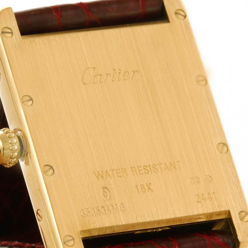 This image shows the backside of a Cartier Tank Louis W1529756 Men's Yellow Gold Silver Dial W1529756 Men's Yellow Gold Silver Dial watch, highlighting the inscriptions and the leather strap.