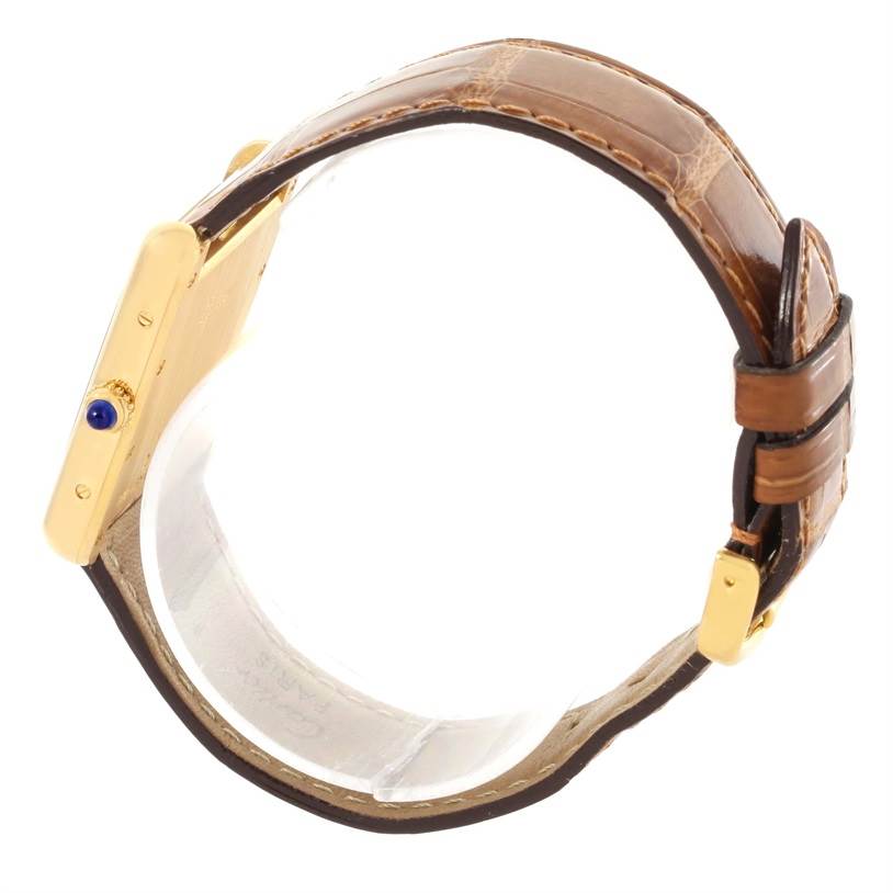 The image shows a side view of a Tank Louis Cartier watch, highlighting its gold case and brown leather strap.