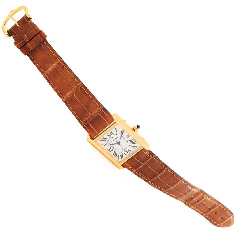 The Cartier Tank Louis W1529756 Men's Yellow Gold Silver Dial W1529756 Men's Yellow Gold Silver Dial watch is shown from an overhead angle, displaying its rectangular face and brown leather strap.