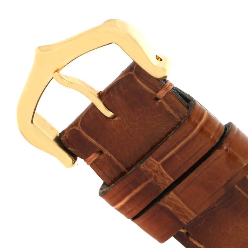 This image shows a close-up of the brown leather strap and gold buckle of the Tank Louis model by Cartier.