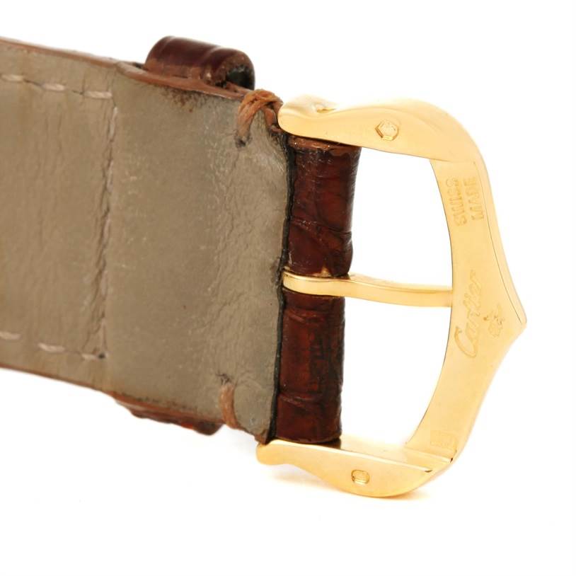 The image shows a close-up of the leather strap and gold buckle of a Tank Louis model by Cartier.