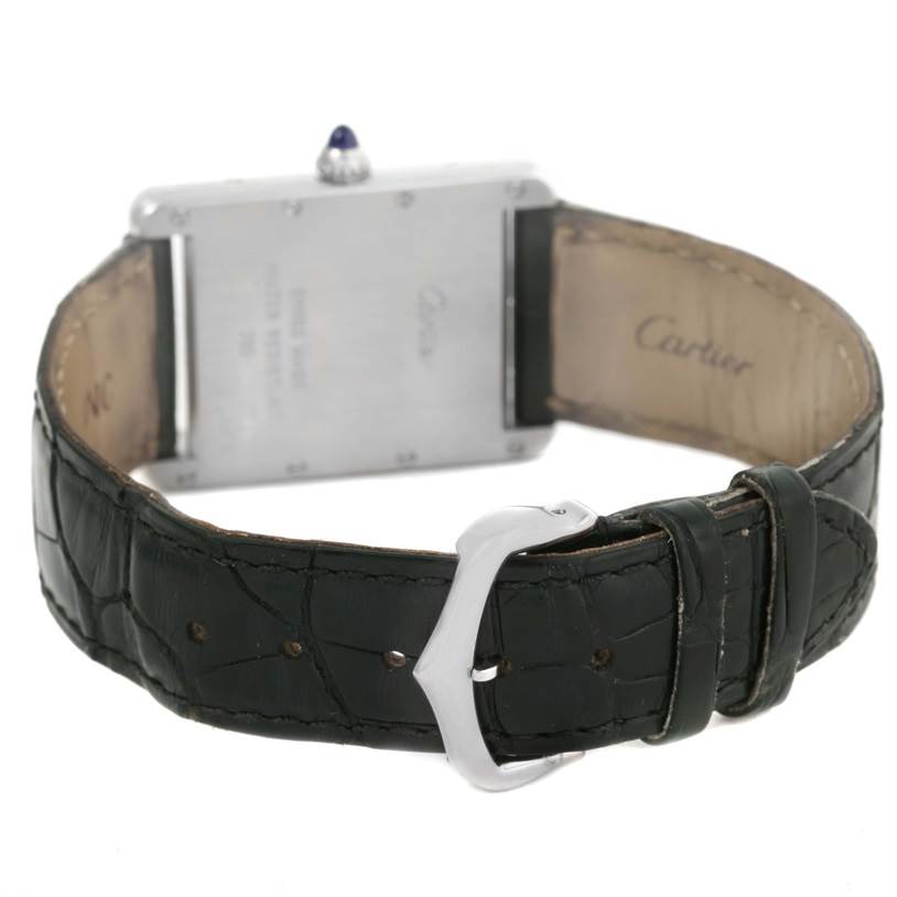 The image shows the Tank Louis watch by Cartier from a rear angle, highlighting the clasp and inscription on the back.