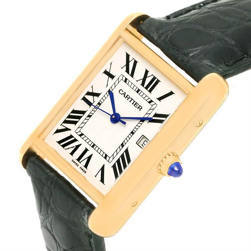 The Tank Louis Cartier watch is shown from a slightly tilted, close-up angle, highlighting its rectangular dial, gold case, and black leather strap.