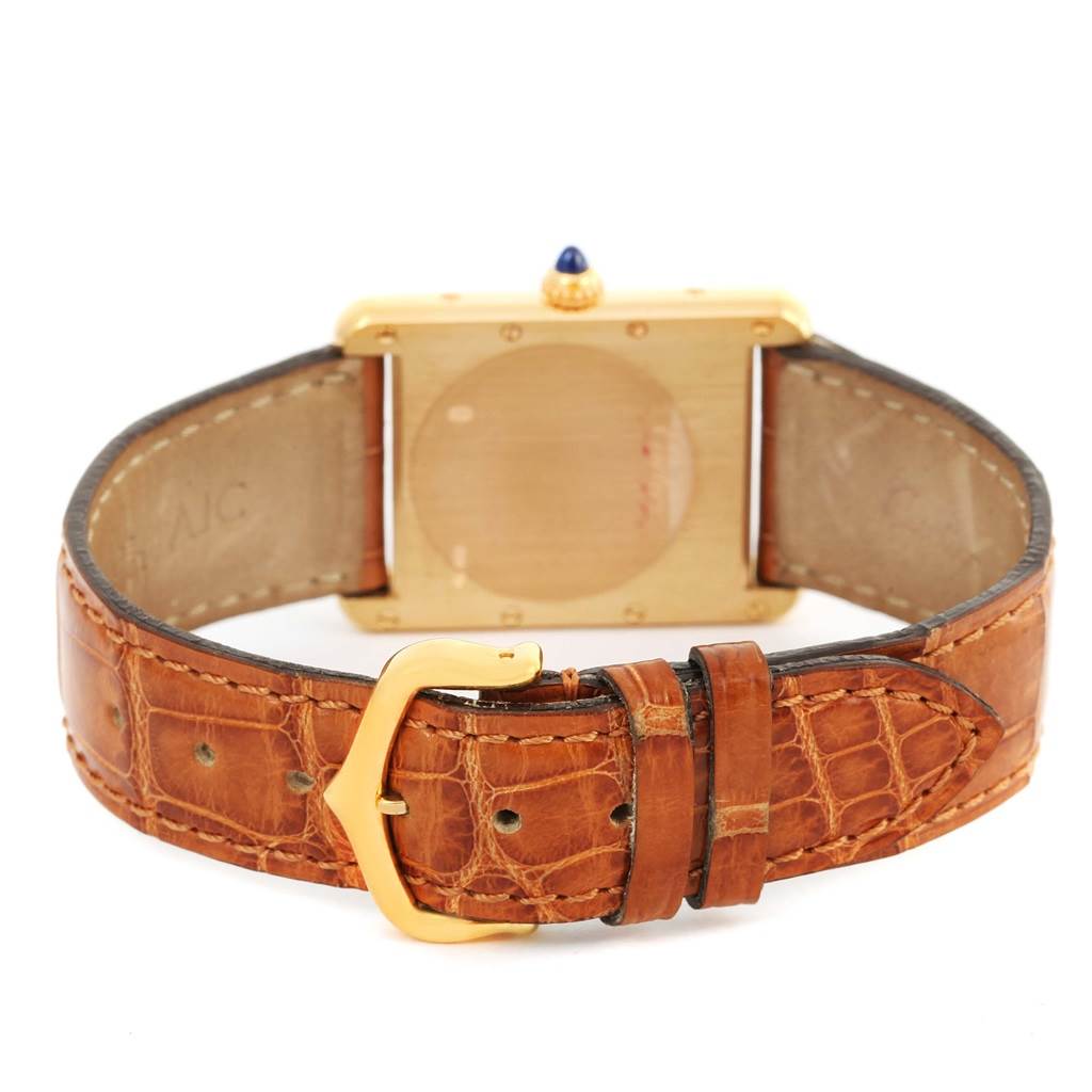 The image shows the back view of the Cartier Tank Louis W1529756 Yellow Gold Silver Dial W1529756 Yellow Gold Silver Dial watch, focusing on the case back and brown leather strap with a gold buckle.