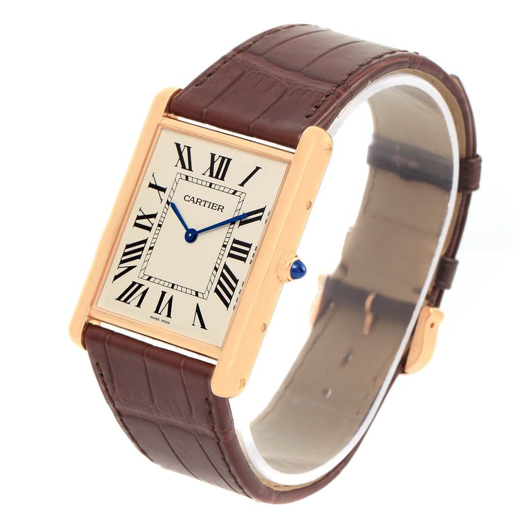 The Tank Louis Cartier watch is shown at a three-quarter angle, highlighting its rectangular dial, brown leather strap, and gold casing.
