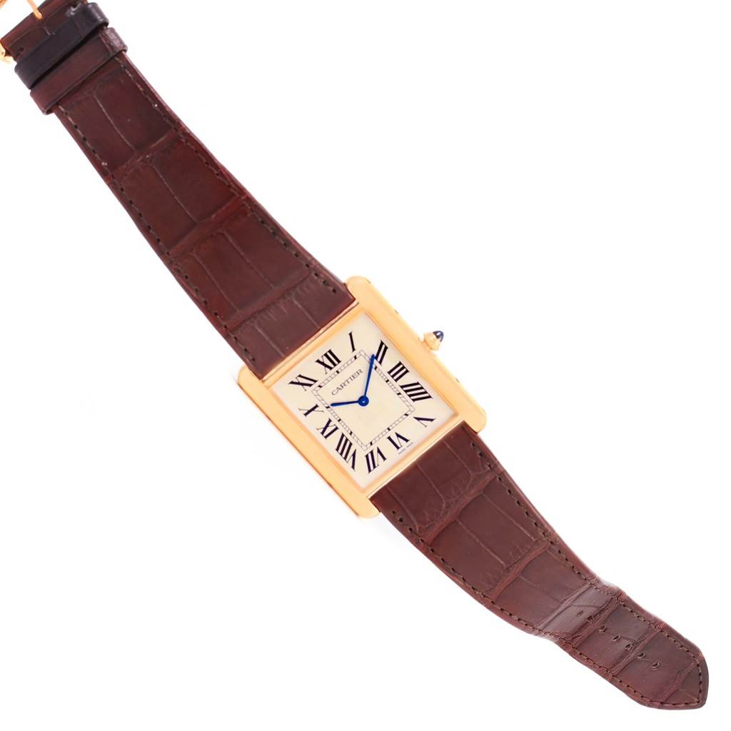 The image shows a full view of a Tank Louis Cartier watch, displaying its rectangular face and brown leather strap.