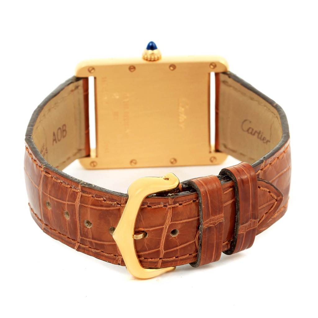 The image shows the back of a Cartier Tank Louis W1529756 Men
s Yellow Gold Silver Dial W1529756 Men
s Yellow Gold Silver Dial watch, featuring its leather strap and gold buckle.