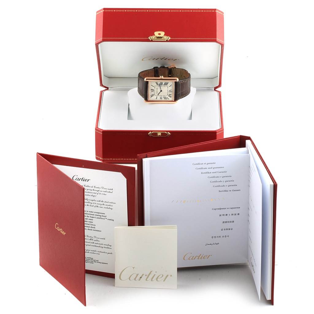 The Tank Louis model by Cartier is shown inside its open box, accompanied by booklets and documentation.