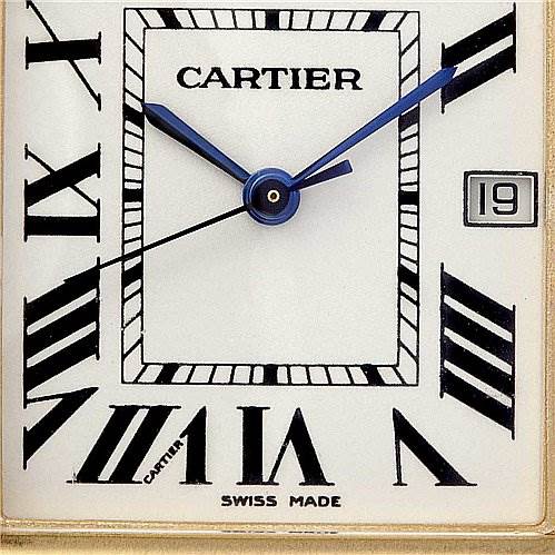 The image shows a close-up of the face of the Cartier Tank Louis W1529756 Yellow Gold White Dial W1529756 Yellow Gold White Dial watch, featuring Roman numerals, blue hands, and a date window.