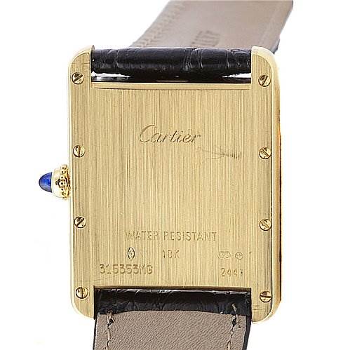 The image shows the back of a Cartier Tank Louis W1529756 Yellow Gold White Dial W1529756 Yellow Gold White Dial watch, highlighting its gold case, leather strap, and inscriptions.