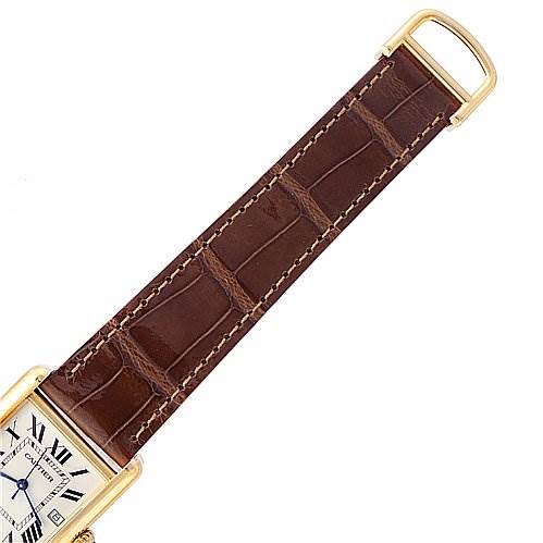 This image shows an overhead view of a Cartier Tank Louis W1529756 Yellow Gold White Dial W1529756 Yellow Gold White Dial watch, focusing on its brown leather strap and part of the watch face.