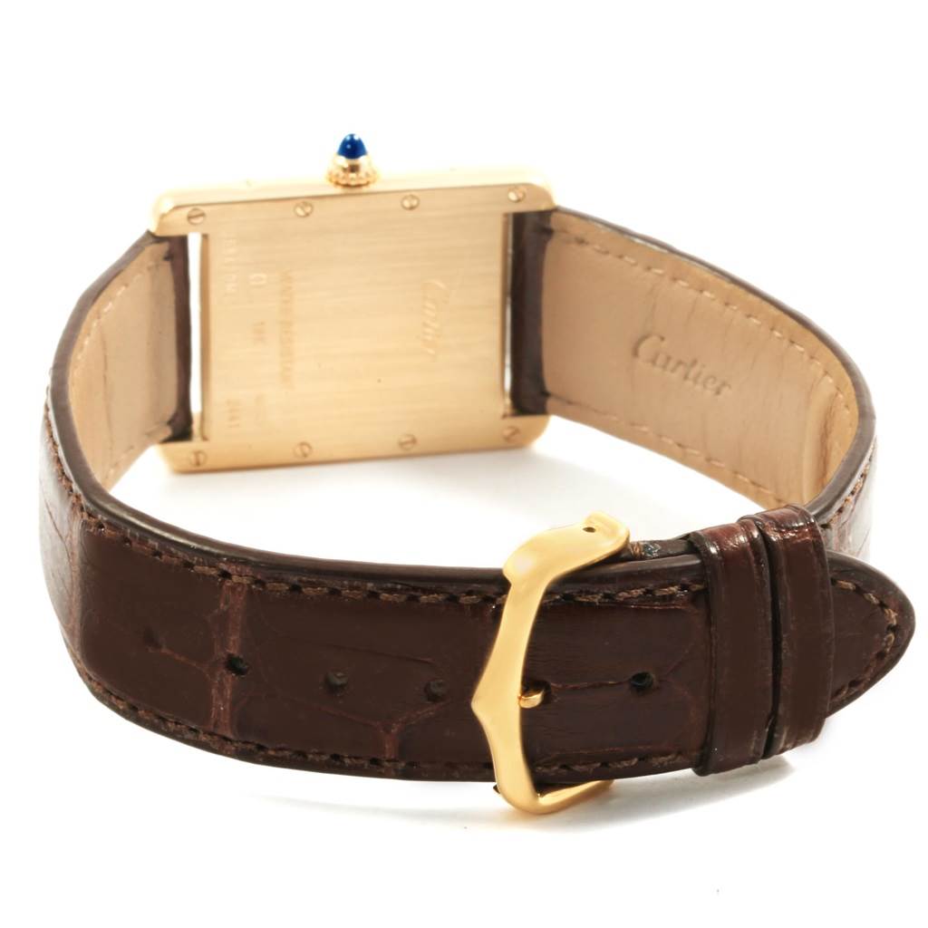 The image shows the backside of a Cartier Tank Louis W1529756 Men
s Yellow Gold Silver Dial W1529756 Men
s Yellow Gold Silver Dial watch, focusing on the leather strap and gold clasp.