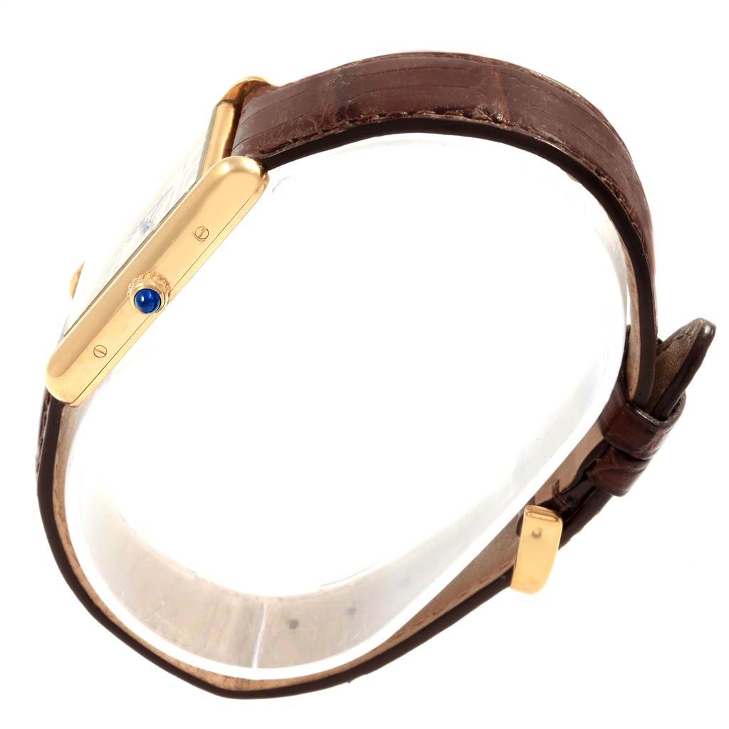 The Cartier Tank Louis W1529756 Men
s Yellow Gold Silver Dial W1529756 Men
s Yellow Gold Silver Dial model watch is displayed from a side angle, highlighting its case, crown, and brown leather strap.