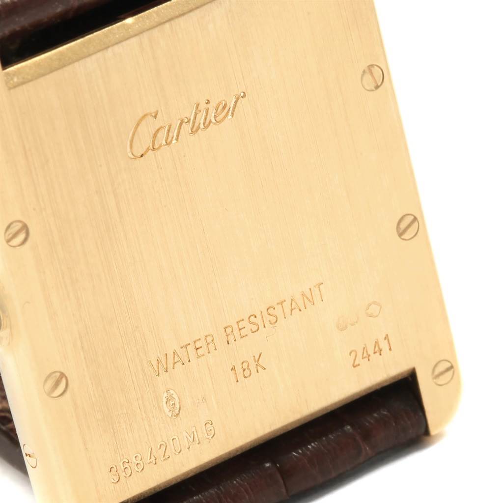 The image shows the back case of a Tank Louis watch by Cartier, highlighting its engravings and screws.