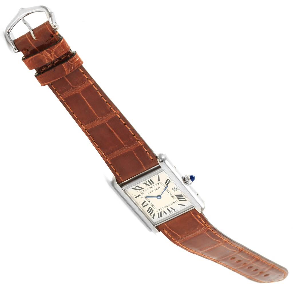 The image shows a Tank Louis model by Cartier from a top view, highlighting the watch face, strap, and buckle.