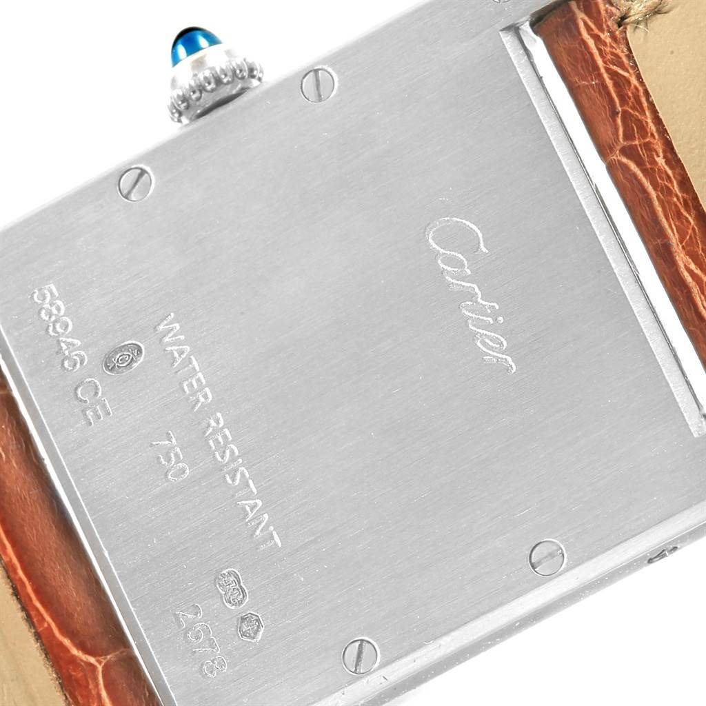 The image shows the back side of a Tank Louis Cartier watch with the leather strap partially visible.