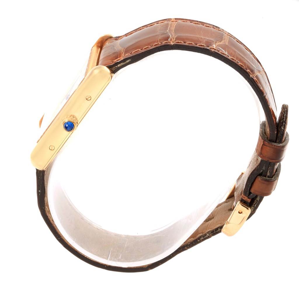 The image shows a side view of the Cartier Tank Louis W1529756 Men
s Yellow Gold Silver Dial W1529756 Men
s Yellow Gold Silver Dial watch featuring its gold case, blue crown, and brown leather strap.