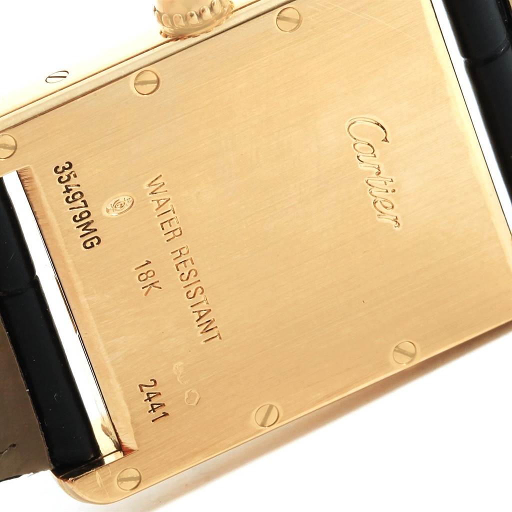 The image shows the back case of a Cartier Tank Louis W1529756 Men's Yellow Gold Silver Dial W1529756 Men's Yellow Gold Silver Dial watch with engraved details such as water resistance and gold content.