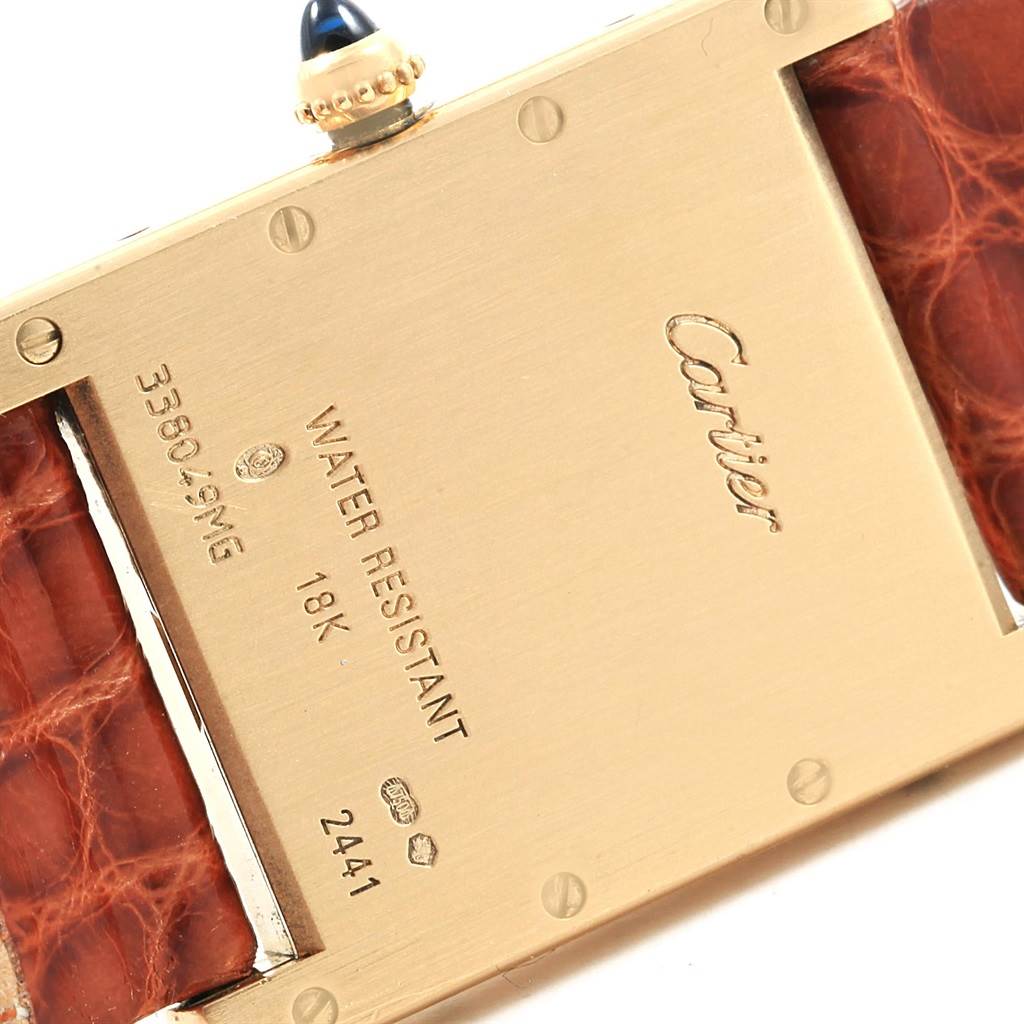 This image shows the back casing, crown, and part of the strap of a Tank Louis model by Cartier.