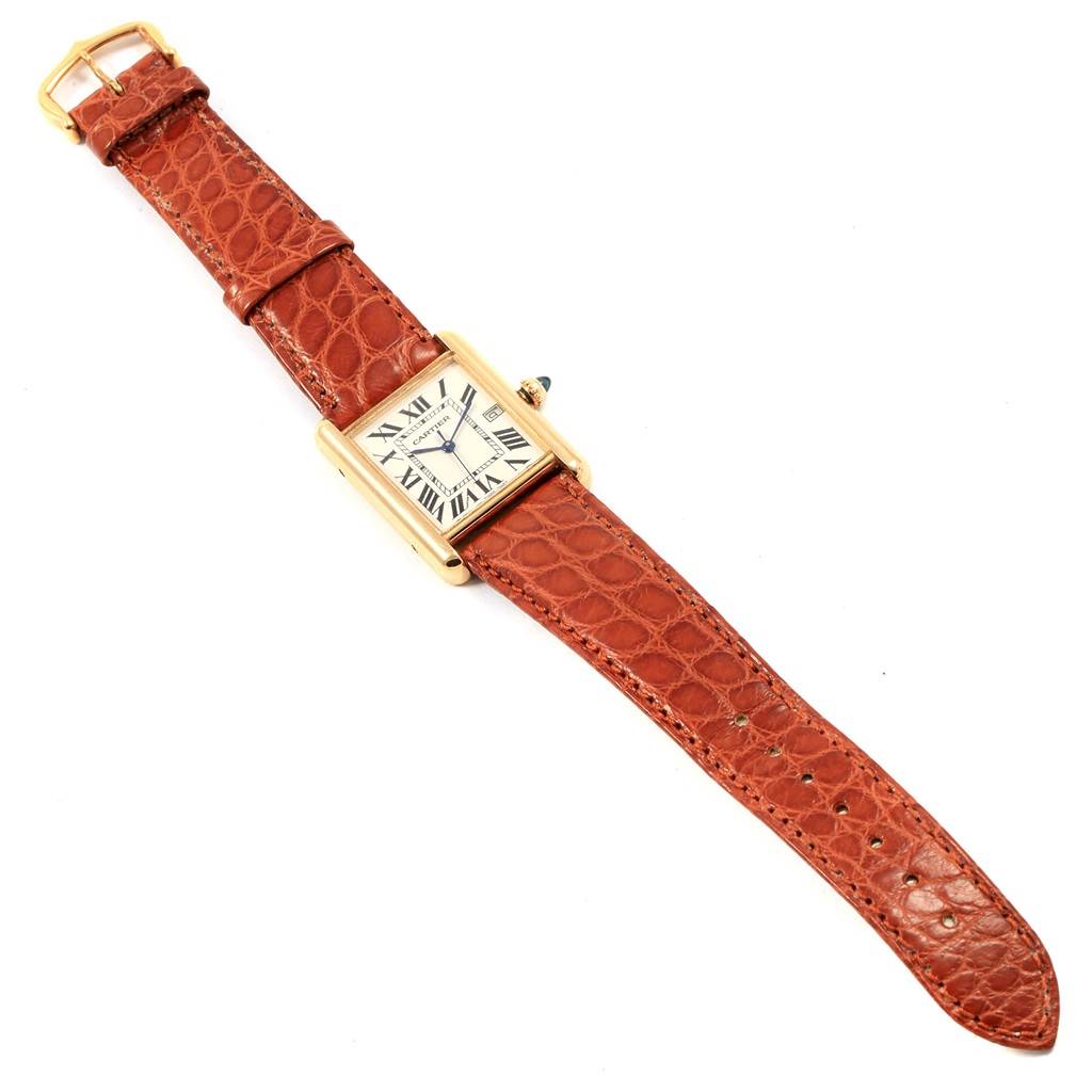 The Tank Louis model by Cartier is shown from a top-down angle, displaying the case, dial, and full leather strap.