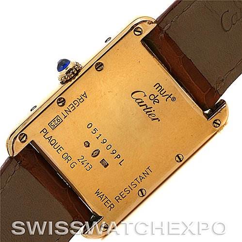 The image shows the back of a Tank Louis Cartier watch, displaying the case, model, and various engravings.