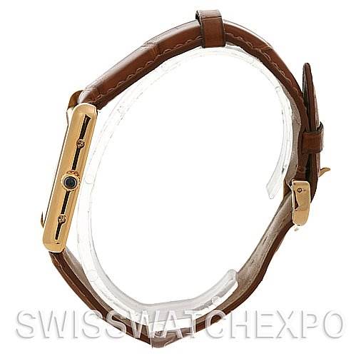 The image shows a side view of the Tank Louis model watch by Cartier, highlighting the brown leather strap and gold case.