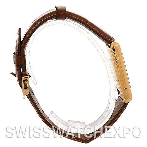 This image shows a Cartier Tank Louis W1529756 Yellow Gold White Dial W1529756 Yellow Gold White Dial watch from a side view, highlighting its gold case and brown leather strap.