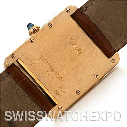 This image shows the back case of a Cartier Tank Louis W1529756 Yellow Gold White Dial W1529756 Yellow Gold White Dial watch, highlighting the brand engraving and blue cabochon crown.