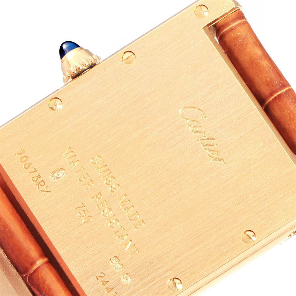 This image shows the back case of a Cartier Tank Louis W1529756 Men's Yellow Gold Silver Dial W1529756 Men's Yellow Gold Silver Dial watch, displaying engravings and part of the strap and crown.