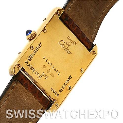 This image shows the back case of a Cartier Tank Louis Yellow Gold White Dial Yellow Gold White Dial watch, along with part of its leather strap and crown.