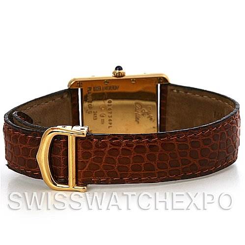 The image shows the back view of the Tank Louis model by Cartier, highlighting its gold case back, leather strap, and clasp.