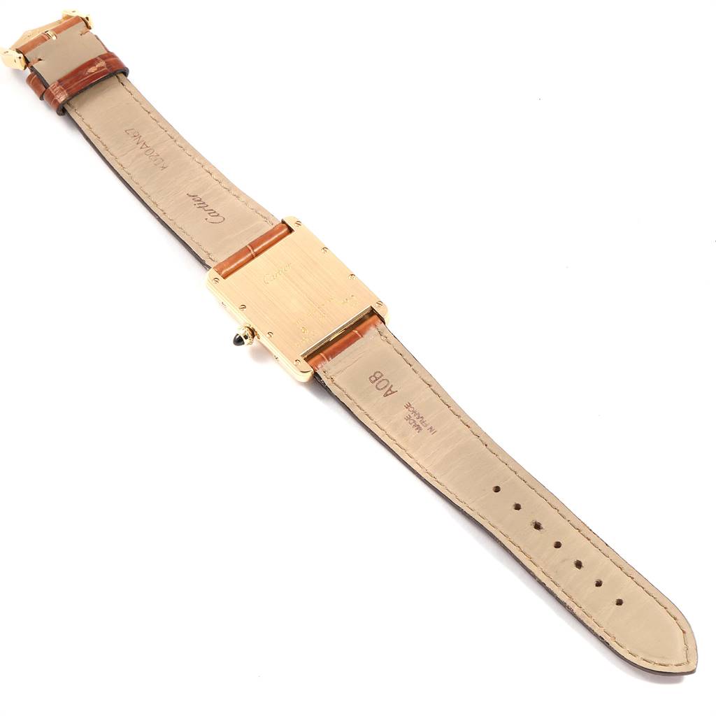 The image shows the back side of a Tank Louis model watch by Cartier, displaying its case back and leather strap.