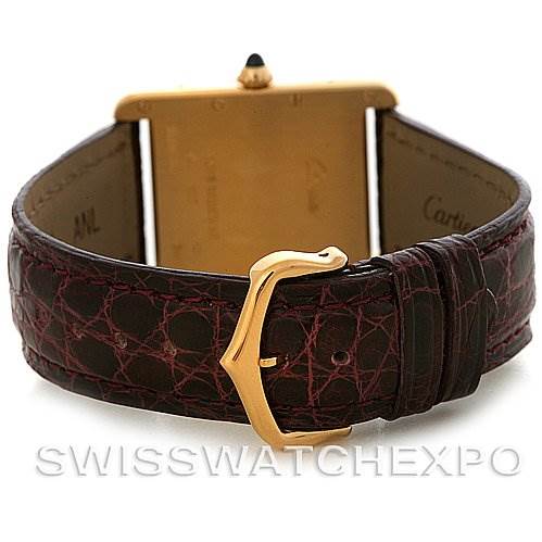 The image shows the back view of the Tank Louis watch by Cartier, featuring its gold buckle and leather strap.