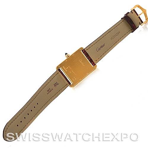 The image shows the back of a Tank Louis model by Cartier, highlighting the strap, buckle, and case back.