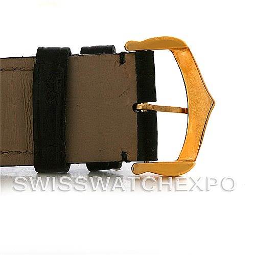 The image shows a close-up of the gold buckle and part of the leather strap of a Tank Louis model watch by Cartier.