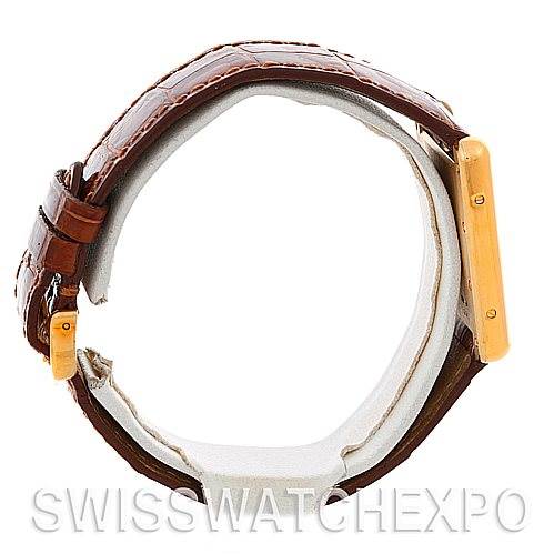 The image shows a side view of a Cartier Tank Louis W1529756 Men
s Yellow Gold Silver Dial W1529756 Men
s Yellow Gold Silver Dial watch focusing on the brown leather strap and golden case.