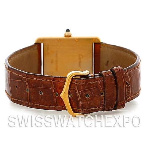 The image shows the back view of a Tank Louis model by Cartier, highlighting the brown leather strap and gold buckle.